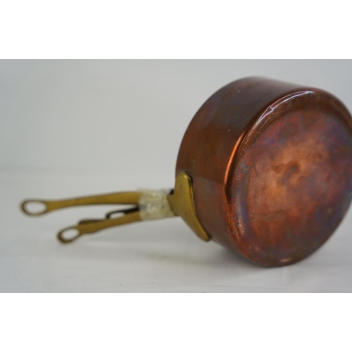 365 - A set of 6 antique graduating copper saucepans with brass handles.