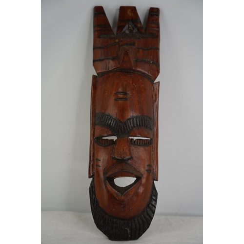 52 - A carved wooden tribal mask wall plaque.