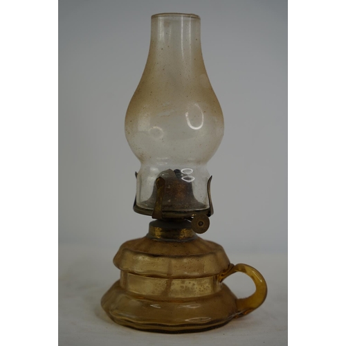 62 - A vintage amber glass finger lamp.