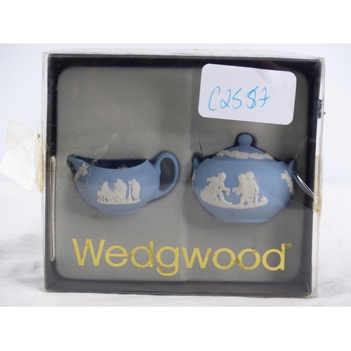 216 - A miniature Wedgwood blue and white jug and lidded bowl set in original box.