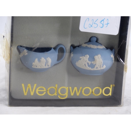 216 - A miniature Wedgwood blue and white jug and lidded bowl set in original box.