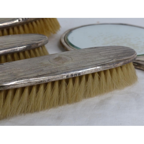 492 - A set of Sterling silver backed dressing table brushes and mirror.