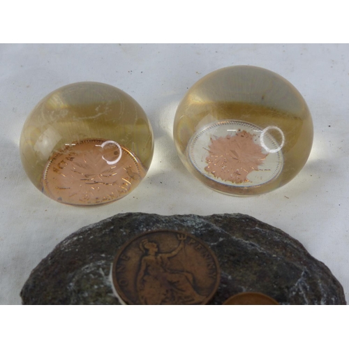 496 - A coin inset wall plaque and two resin coin paperweights.