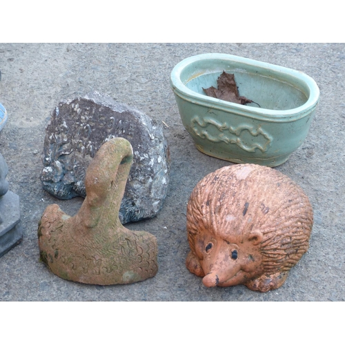 46 - A large assortment of garden ornaments and a planter.