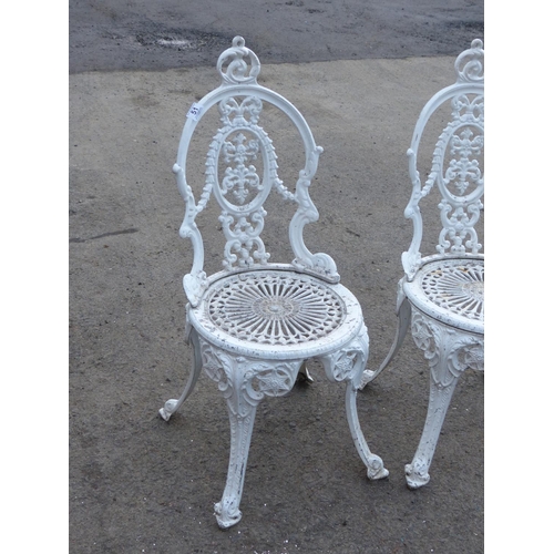 51 - A pair of decorative cast metal garden chairs.