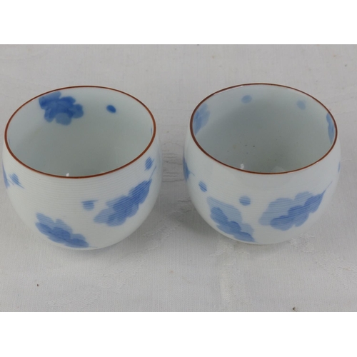 202 - A pair of antique Chinese blue and white patterned tea bowls, each signed to base.
