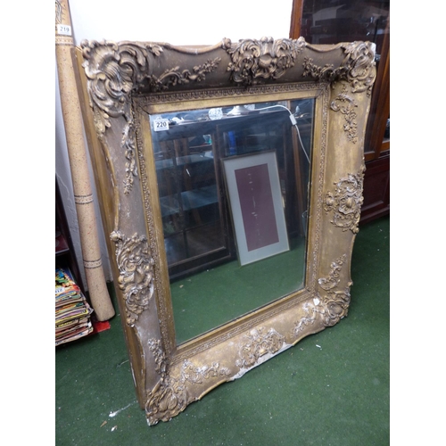 220 - A large antique heavy framed wall mirror with decorative gilt frame.. 1,6 meters x 88cm