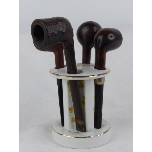 231 - A vintage ceramic pipe stand and four pipes.