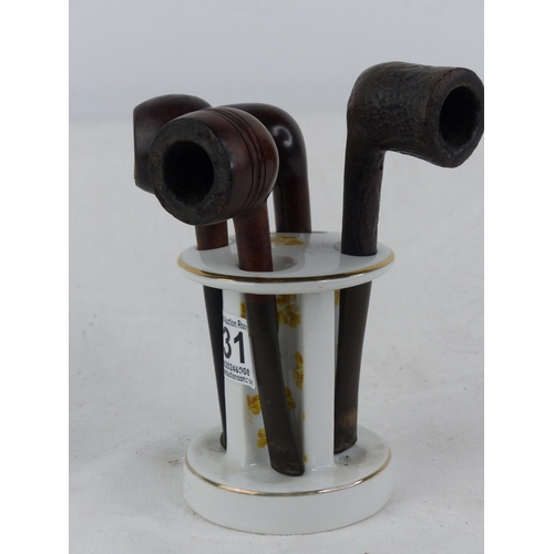 231 - A vintage ceramic pipe stand and four pipes.