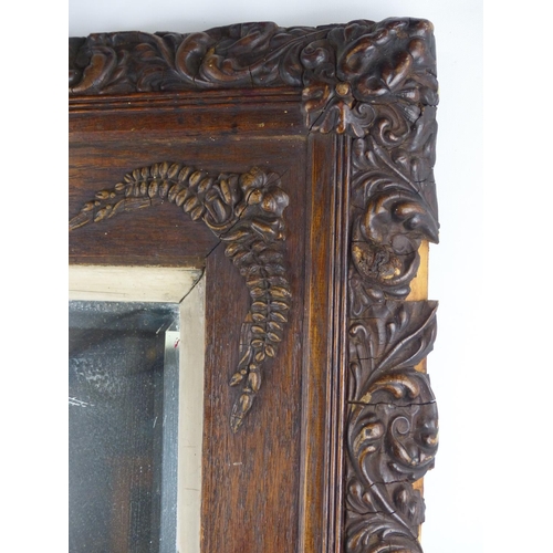 81 - A stunning oak framed wall mirror with carved detail, measuring 75cm x 66cm.