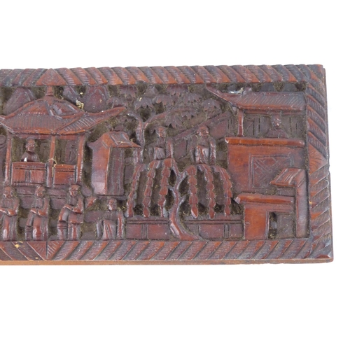 98 - A carved wooden panel with Oriental design, measuring 23cm x 8.5cm.