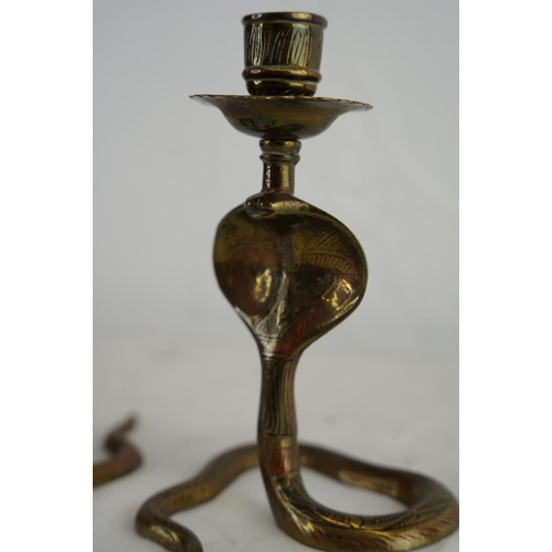 166 - A pair of Indian brass 'cobra' candlesticks.