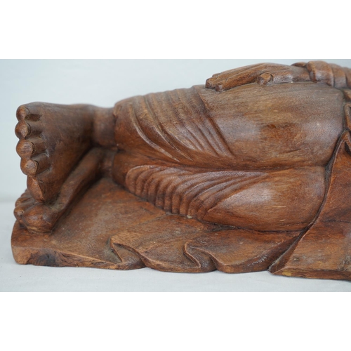 180 - A large wooden reclining Buddha, 64cm.