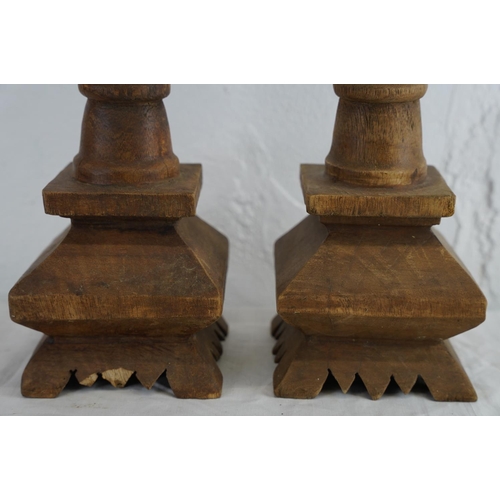 185 - A pair of large wooden carved candlesticks, measuring 21