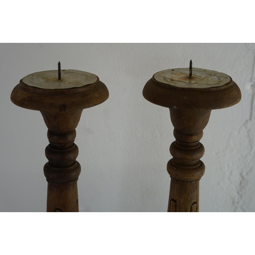 185 - A pair of large wooden carved candlesticks, measuring 21