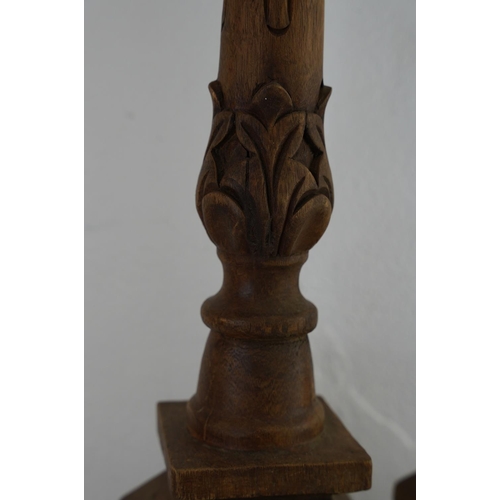 185 - A pair of large wooden carved candlesticks, measuring 21