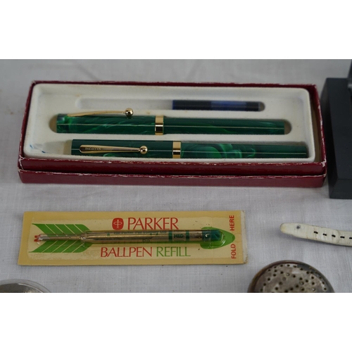 224 - A collection of items to include Sheaffer pen set, coins, brooches and more.