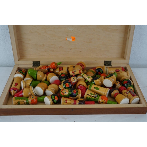 341 - A wooden chess board with Russian doll style chess pieces.