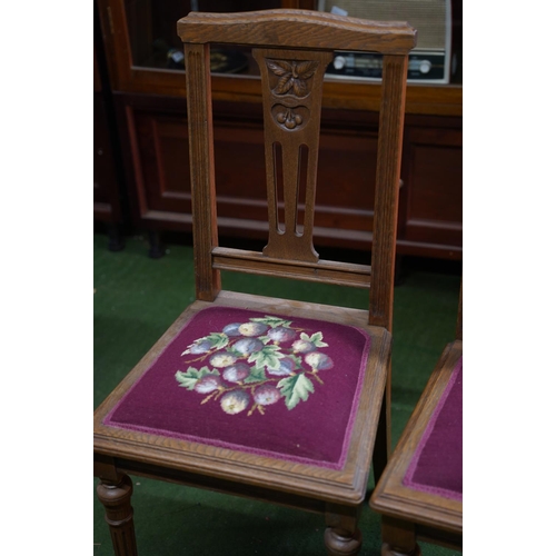 342 - A pair of antique oak carved hall chairs with tapestry panels.