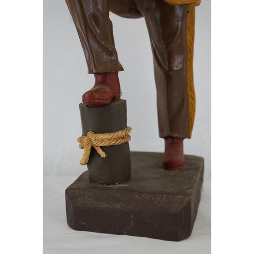 374 - A large wooden figure of a cowboy, 61cm.