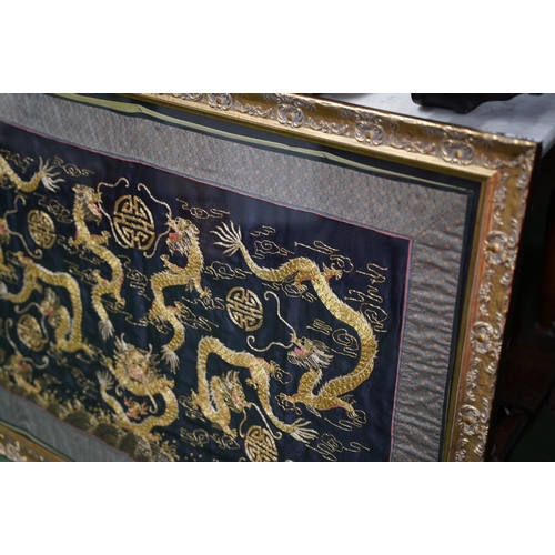 391 - A large gilt framed silk panel, measuring 125cm x 81cm.