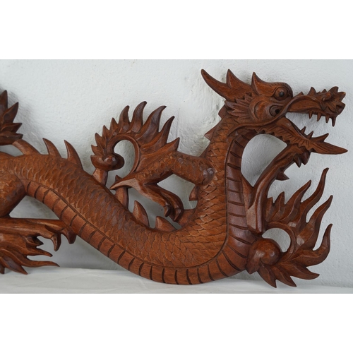 415 - A wooden plaque of a dragon, measuring 60cm.