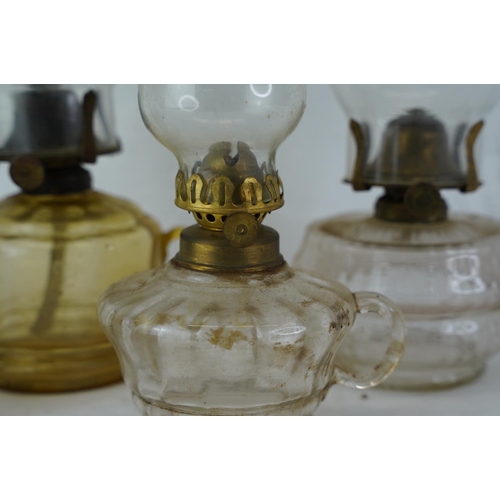 424 - Four vintage clear and coloured glass finger lamps.