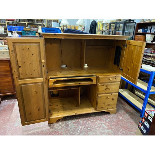 115 - A pine enclosed computer desk with side drawers.