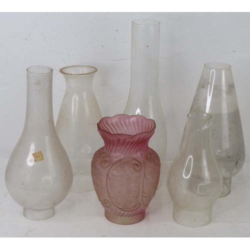 88 - A collection of vintage glass chimneys and a ruby glass shade.