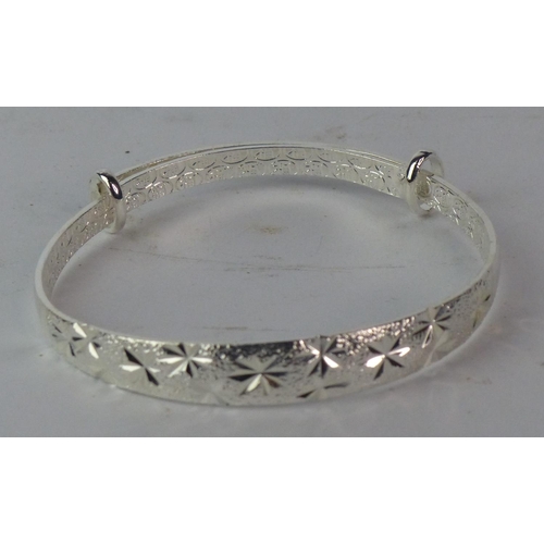 140 - An engraved silver bangle, stamped S990.