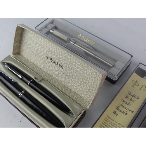 175 - A boxed vintage Parker pen set and three others.