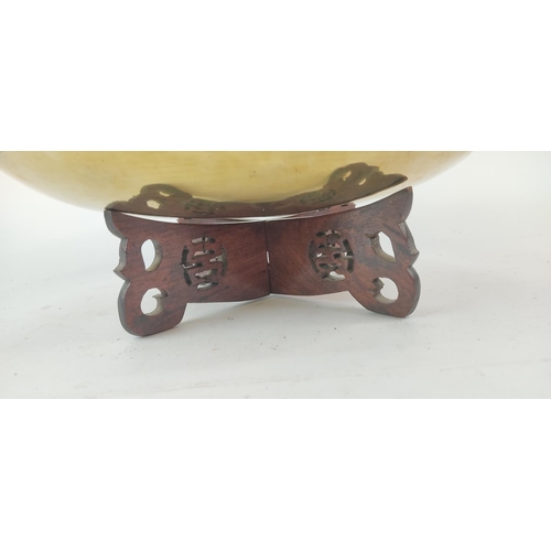 387 - A vintage brass and engraved bowl on a hardwood stand. Diameter measuring 36cm.