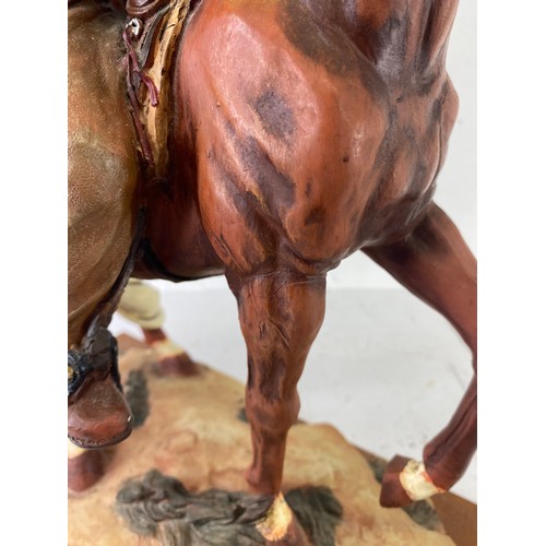 46 - A large resin figure of a cowboy on horseback, 45cm.