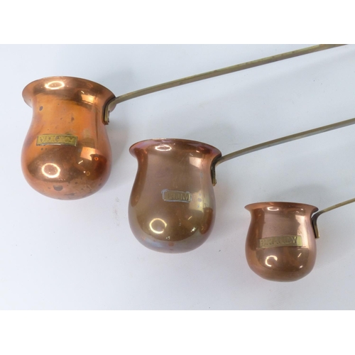 34 - Three vintage brass and copper measures - Brandy, Rum and Whisky.