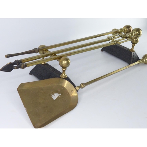 44 - A vintage brass fireside companion set, complete with dogs.