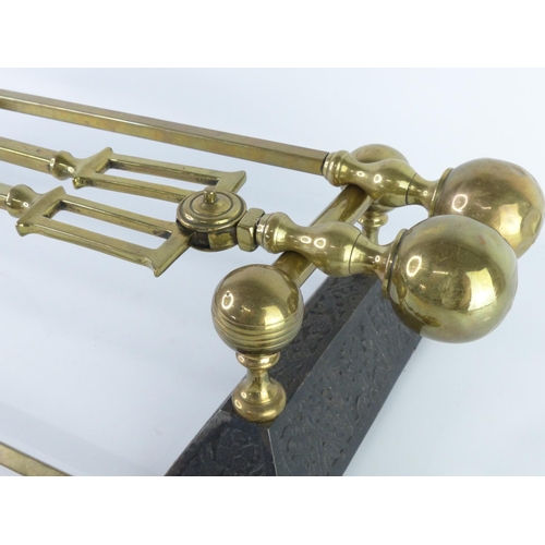 44 - A vintage brass fireside companion set, complete with dogs.