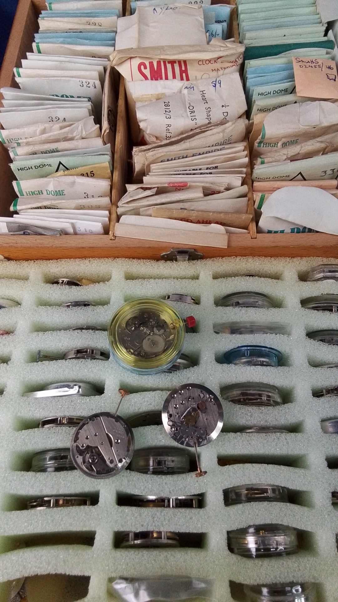 Group of assorted watchmakers’ parts, including numerous packeted ...