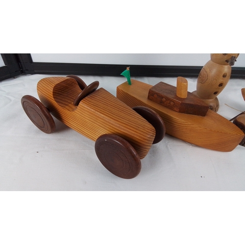 14 - Set of five hand-turned wooden ornaments comprising a toy racing car, toy boat, snowman figure, and ... 
