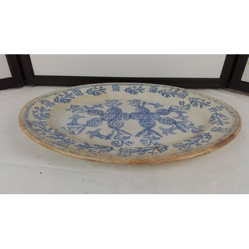 101 - An Irish spongeware platter, printed in blue with floral wreaths and foliate border, on a cream grou... 