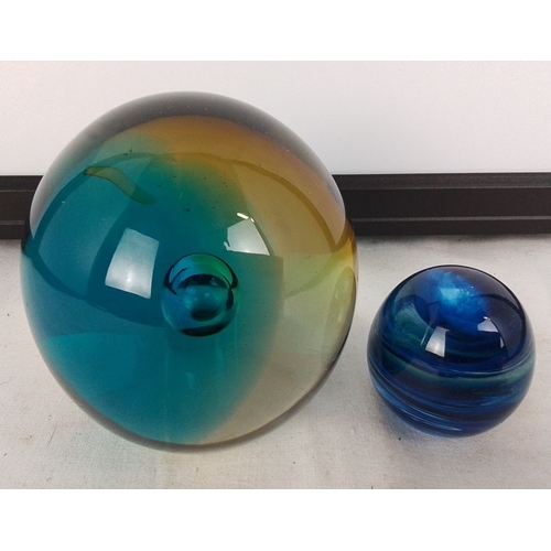 180 - Pair of studio art glass spheres, comprising a large teal-to-amber iridescent orb and a smaller coba... 