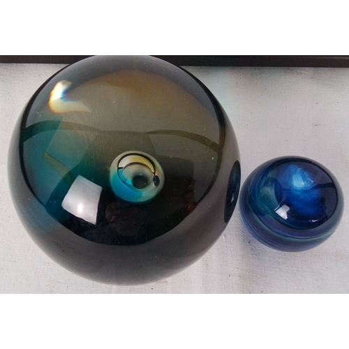180 - Pair of studio art glass spheres, comprising a large teal-to-amber iridescent orb and a smaller coba... 