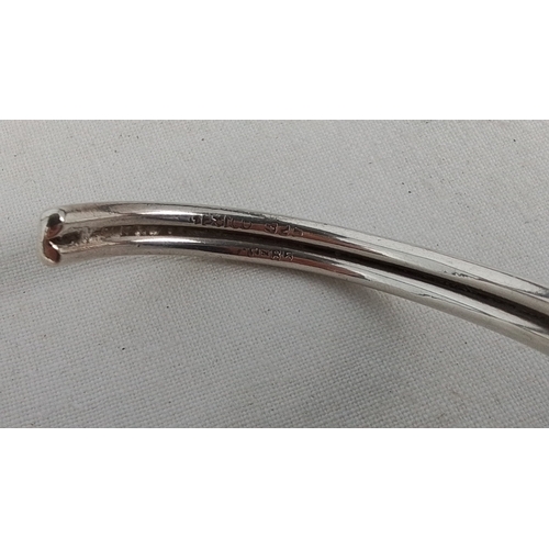 182 - A Mexican sterling silver open bangle, of rounded wire form with a central knot motif; stamped “925”... 