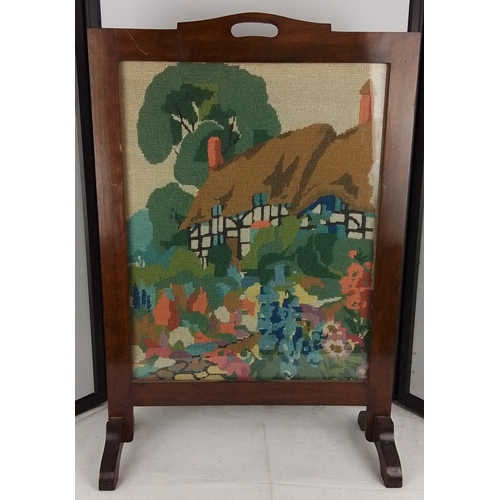205 - A vintage needlepoint firescreen depicting a half-timbered cottage garden landscape, within a wooden... 