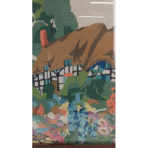 205 - A vintage needlepoint firescreen depicting a half-timbered cottage garden landscape, within a wooden... 