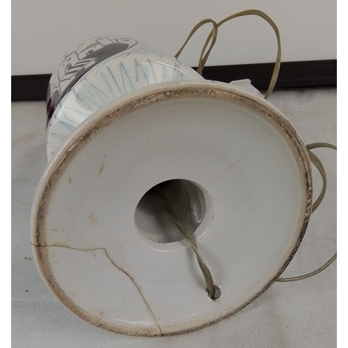 223 - A vintage ceramic table lamp base, of baluster form with flared foot, decorated with stylised villag... 