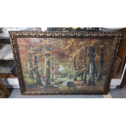 263 - A large landscape painting depicting a wooded autumn scene with a stream, in an ornate gilt-composit... 