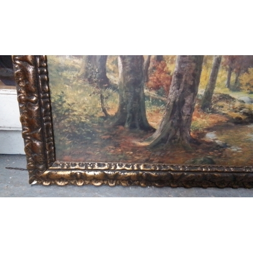 263 - A large landscape painting depicting a wooded autumn scene with a stream, in an ornate gilt-composit... 