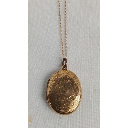 356 - An oval 9ct gold locket pendant, the cover engraved with foliate scrolls and an initialled cartouche... 