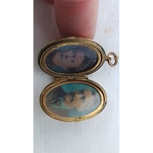 356 - An oval 9ct gold locket pendant, the cover engraved with foliate scrolls and an initialled cartouche... 