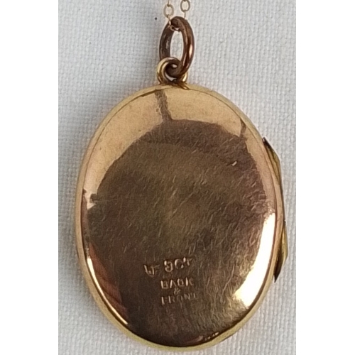 356 - An oval 9ct gold locket pendant, the cover engraved with foliate scrolls and an initialled cartouche... 